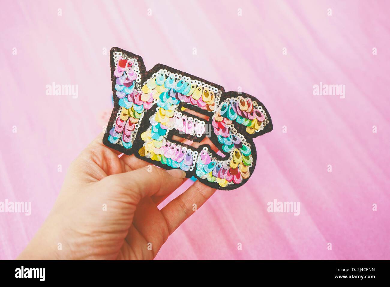 Word 'yes' make with colorful sequins against pink background Stock Photo