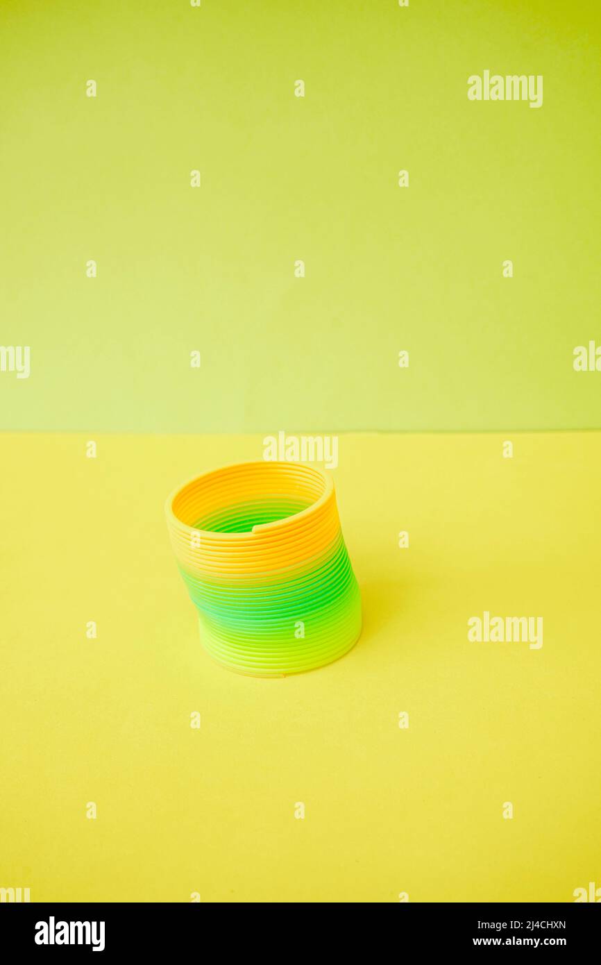 Isolated and colorful slinky toy in yellow orange and green tones Stock Photo
