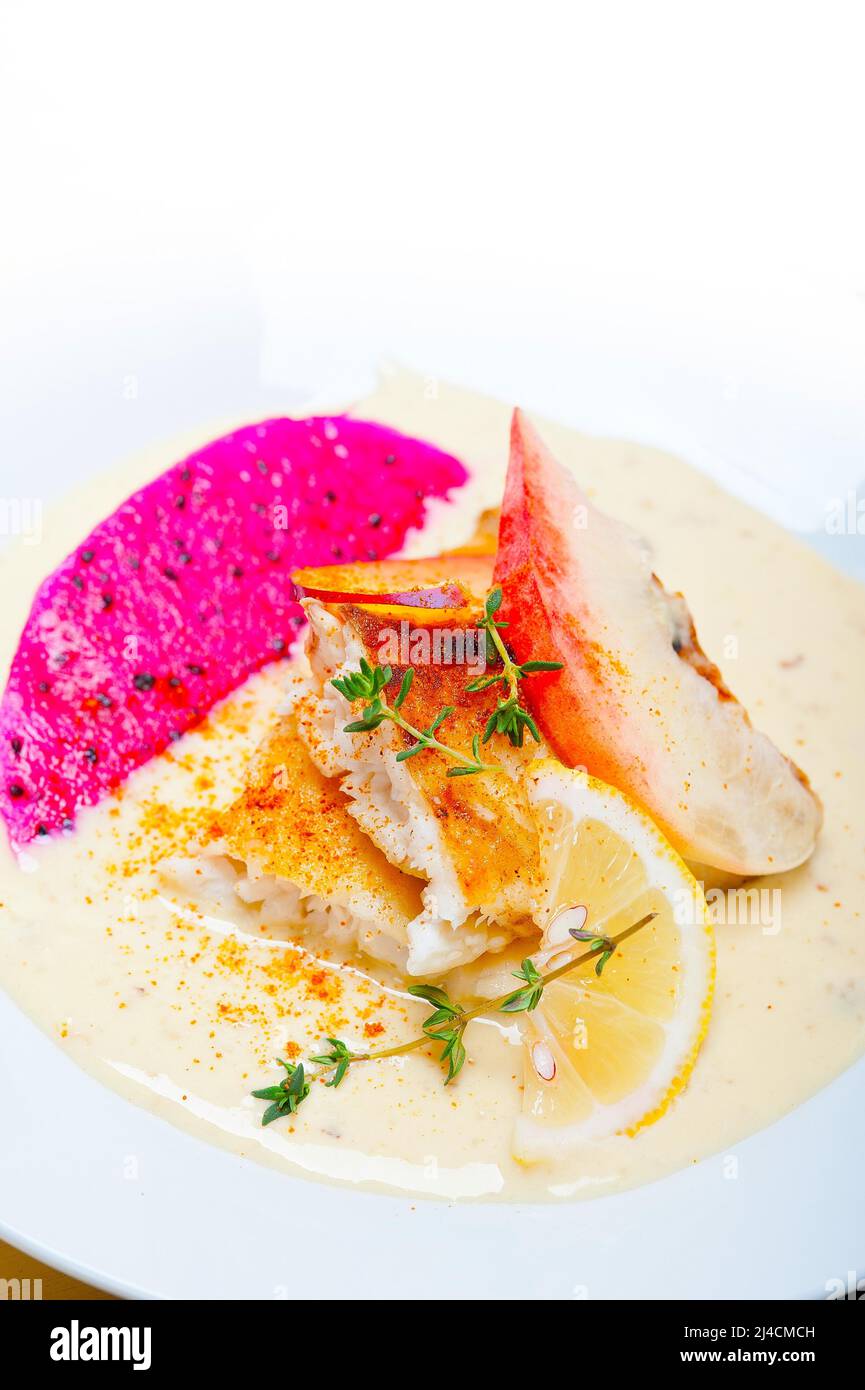 Sea bream orata fillet butter pan fried with fresh peach prune and dragonfruit slices thyme on top Stock Photo