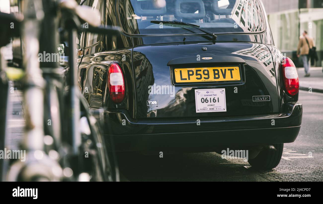 Greater London, London, UK - April 12, 2022: A classic London black taxi cab, captured on a London street. The number plate is visible as this cab pas Stock Photo