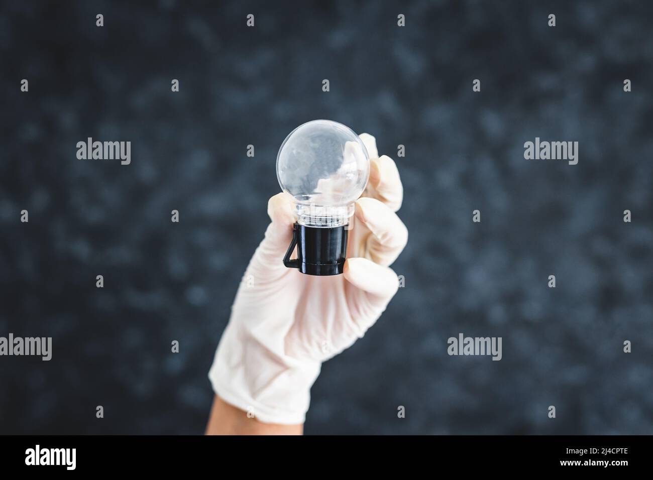 hand with surgical glove holding light bulb metaphor of idea, concept