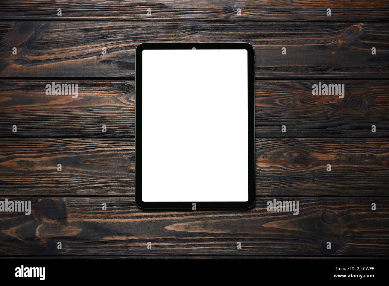 tablet computer with a green screen on a wooden background. Stock Photo