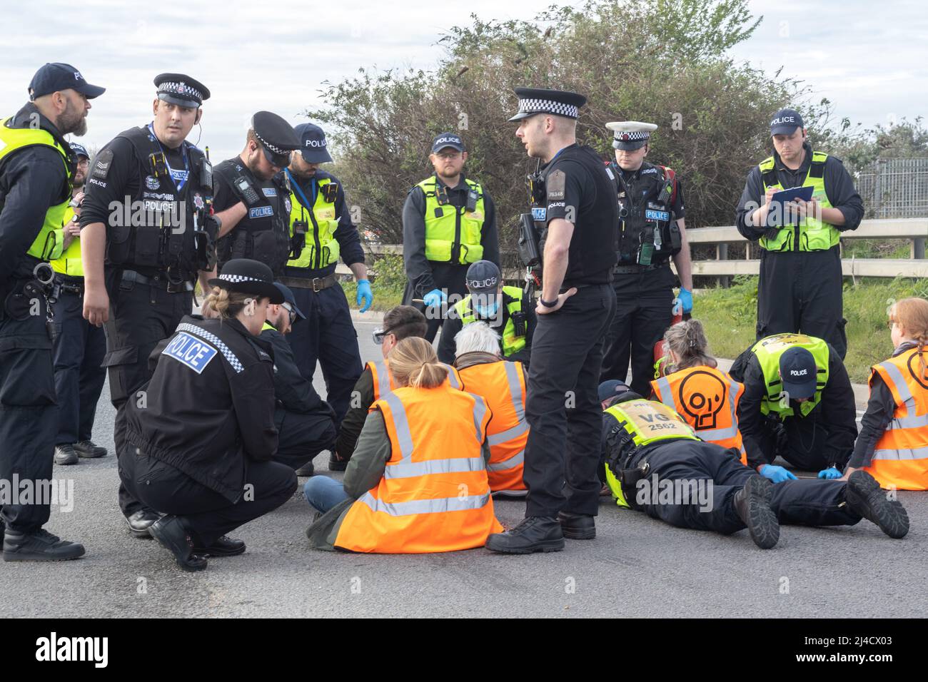 Thurrock, Essex, UK 13 April 2022 Just Stop Oil protesters block a major roundabout climbing aboard two tankers, while several protesters glue themselves to the road. All protesters were removed and arrested. Stock Photo