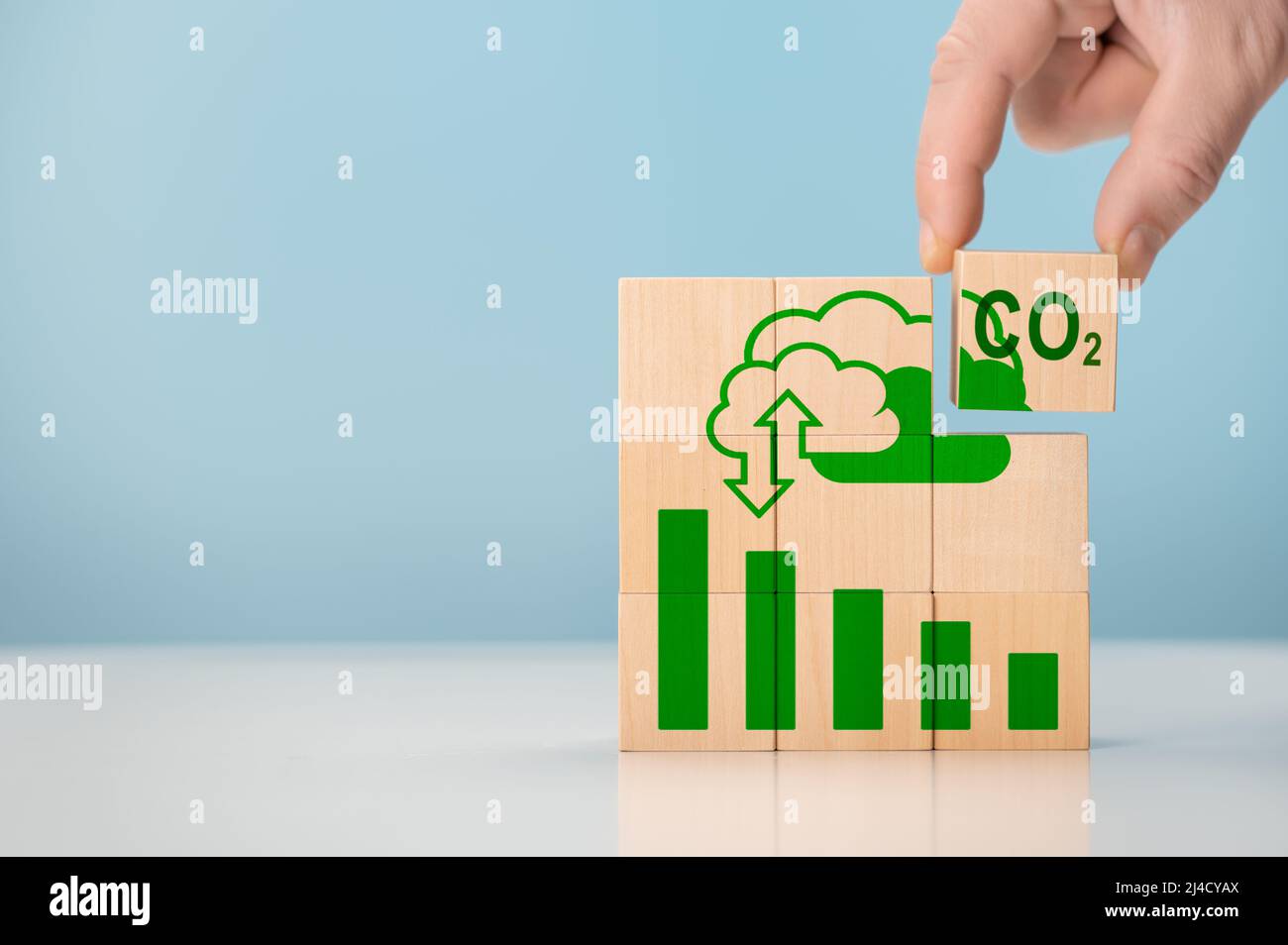 Reduce CO2 emissions. Put wooden cubes with green net zero icon. CO2 Net-Zero Emission Carbon Neutrality concept. renewable energy Stock Photo
