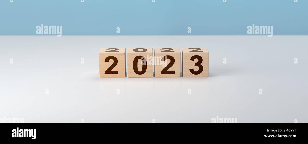 Wooden Blocks With 2022 2023 Number On gray background. new year concept. Wooden cube with flip over block 2022 to 2023 word. Business management, Ins Stock Photo