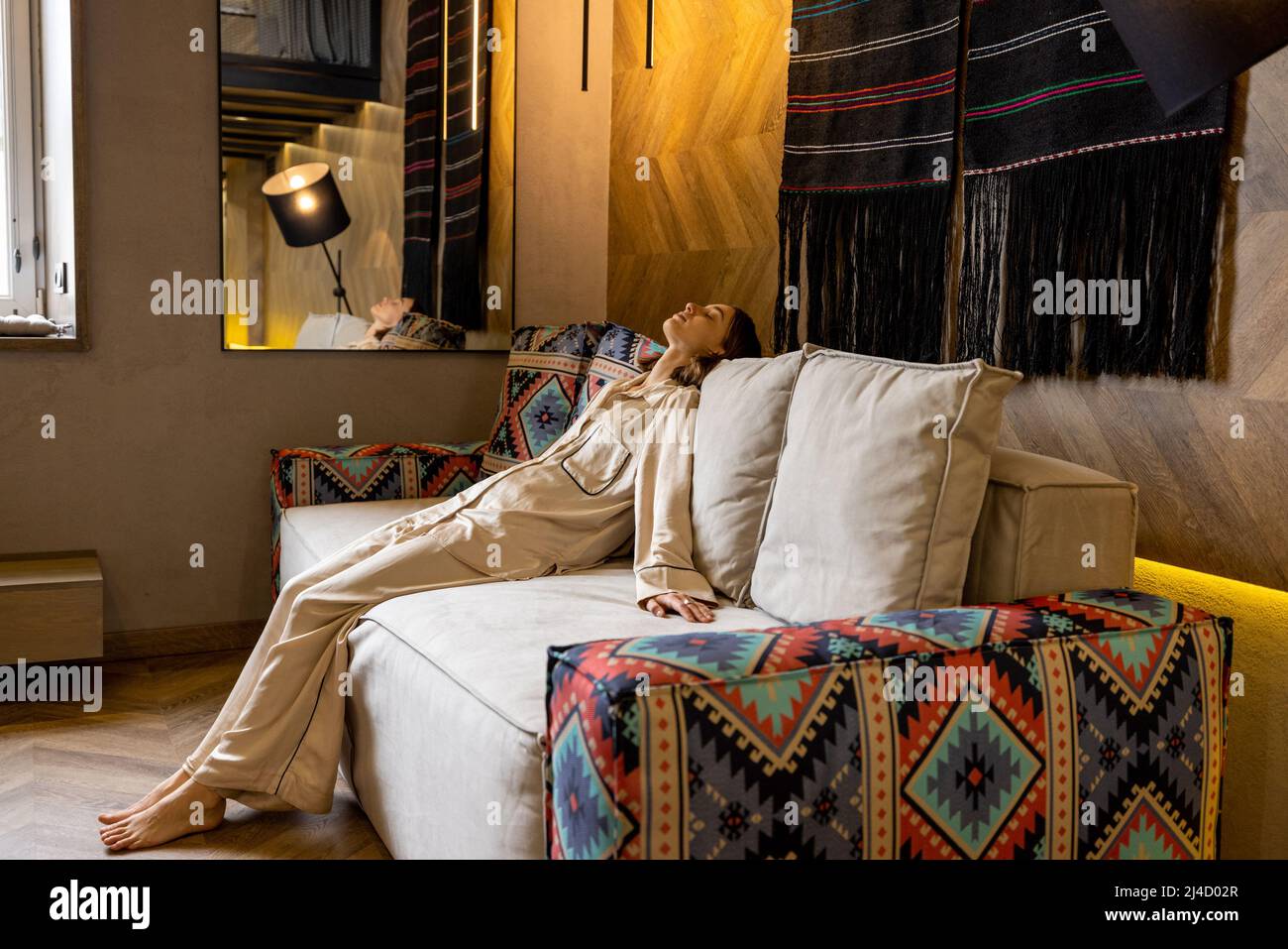 Woman relaxing on couch at modern living room Stock Photo - Alamy