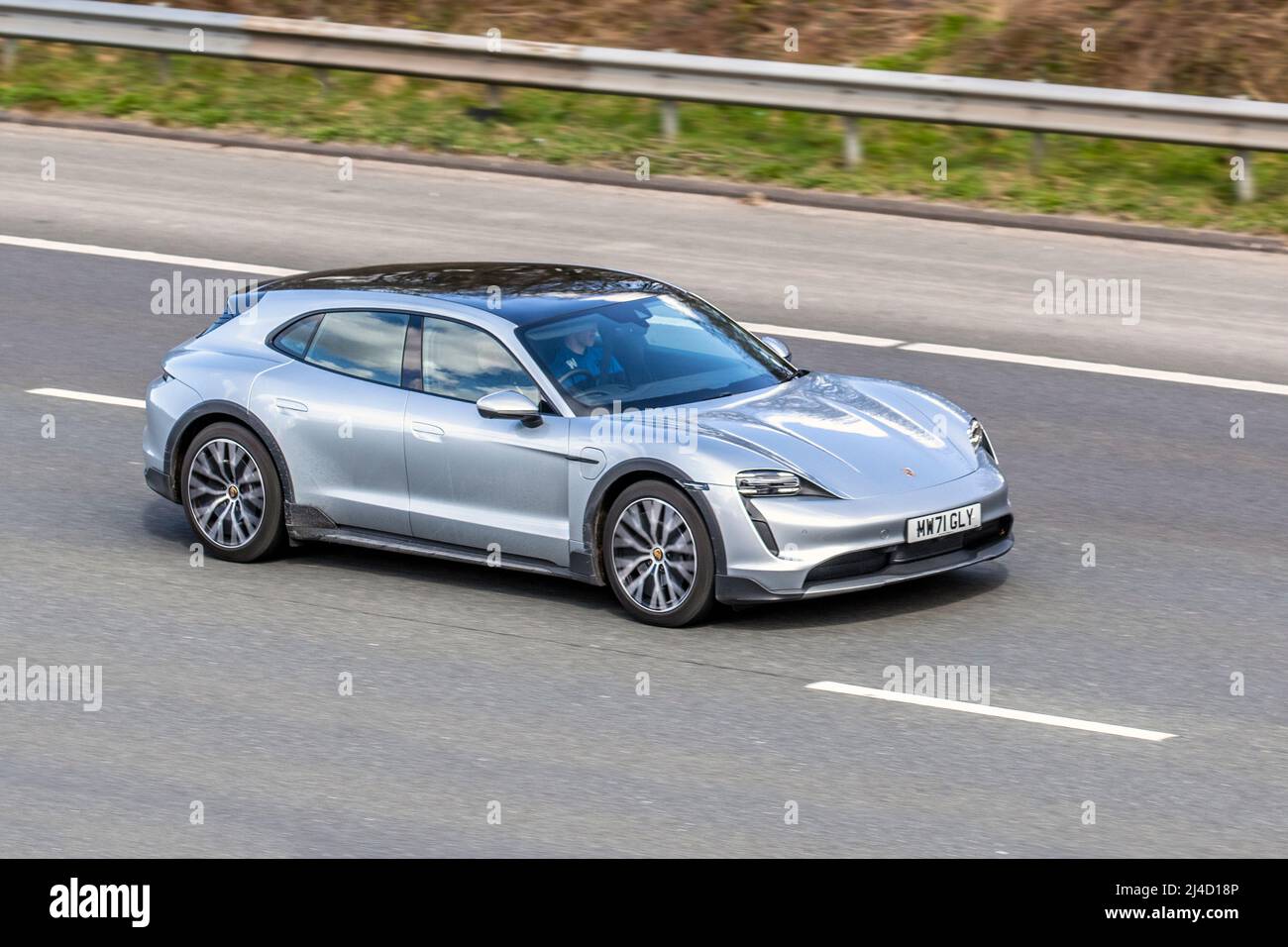 2021 silver Porsche Taycan 4 Cross Turismo Electricity 1 speed automatic,  four-wheel drive sports car driving on the M61 motorway UK Stock Photo