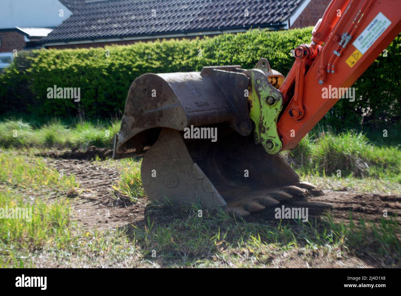 Bucket of Orange Zaxis 210 lc excavator digger being used for