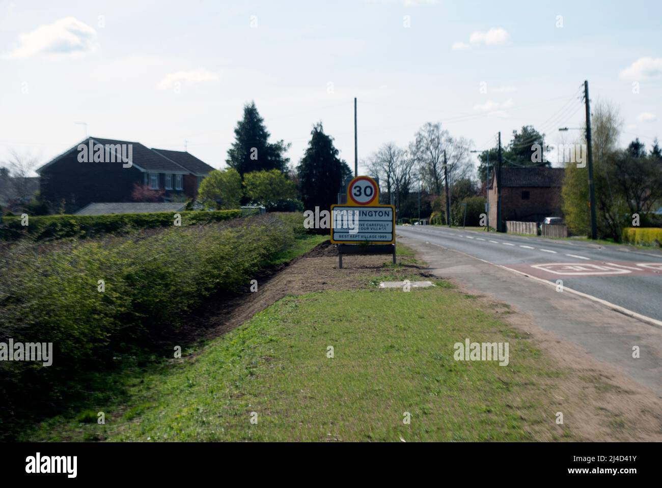 Village name sign for Ruskington and 30 mph speed limit by the side of