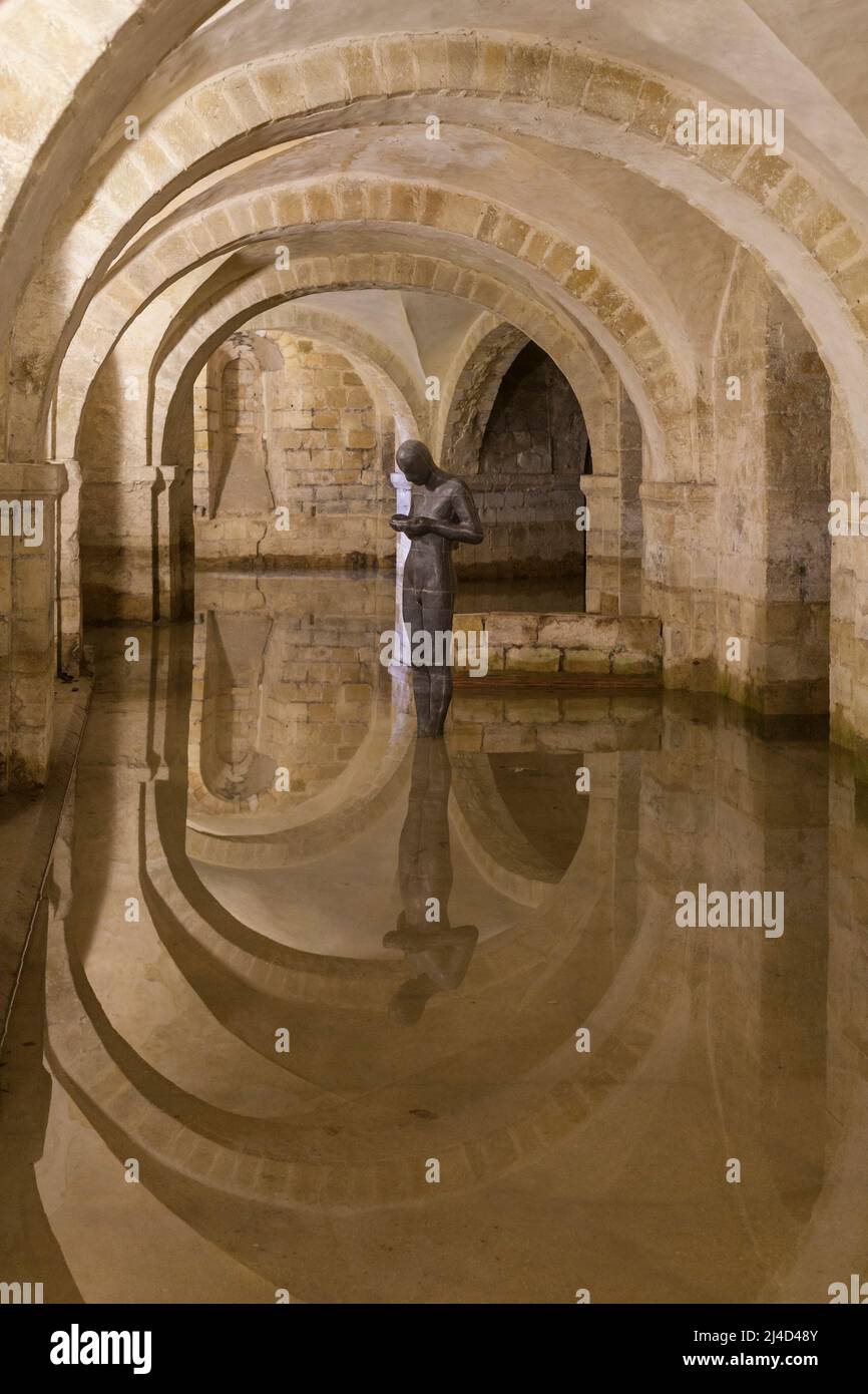 Winchester, Hampshire, UK - May 15, 2014: The flooded crypt of Winchester Cathedral containing the sculpture 'Sound II' by artist Sir Antony Gormley Stock Photo