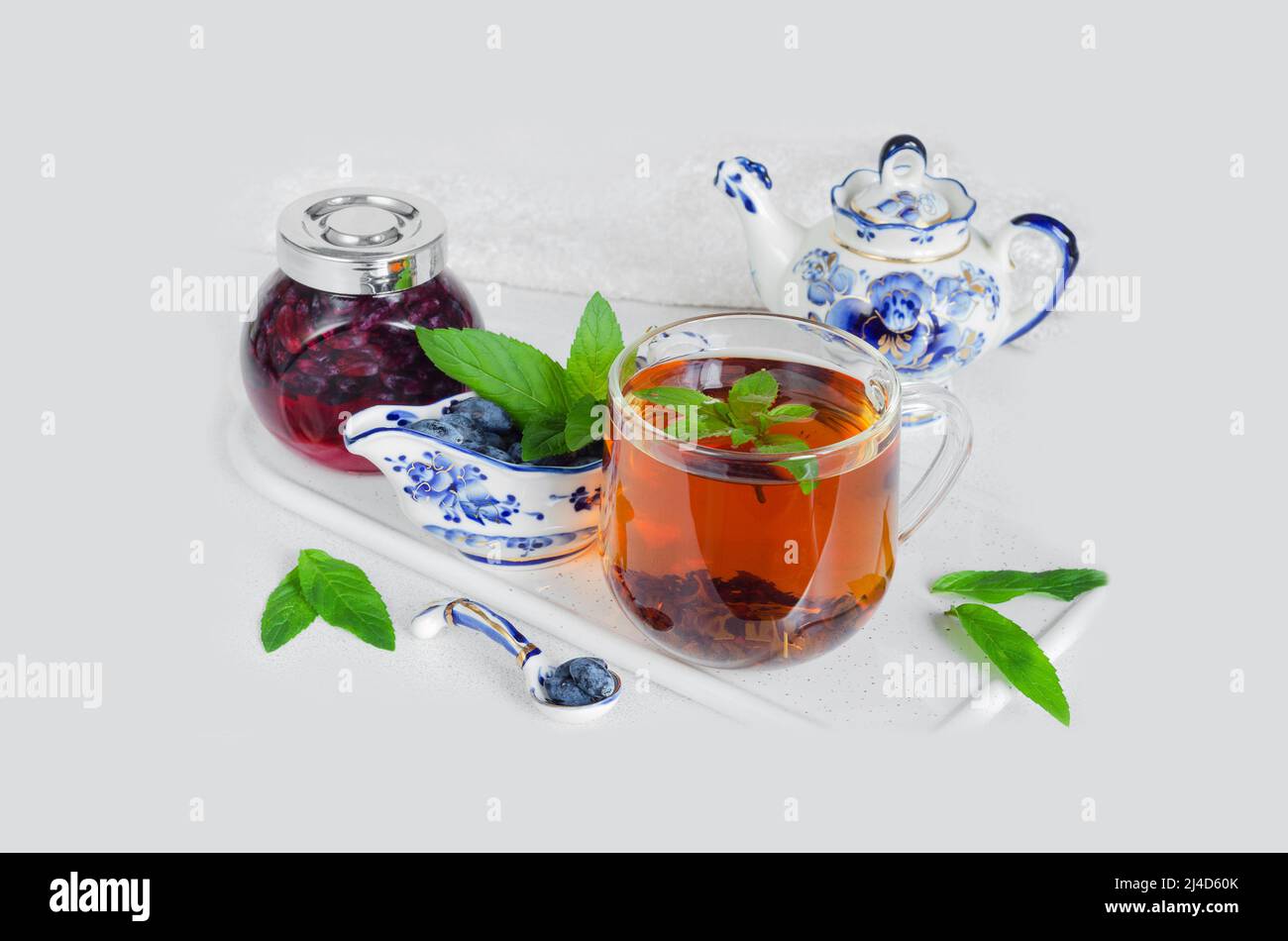 https://c8.alamy.com/comp/2J4D60K/a-cup-of-mint-tea-fresh-honeysuckle-berries-with-sugar-mint-leaves-and-beautiful-dishes-on-the-kitchen-countertop-selective-focus-2J4D60K.jpg