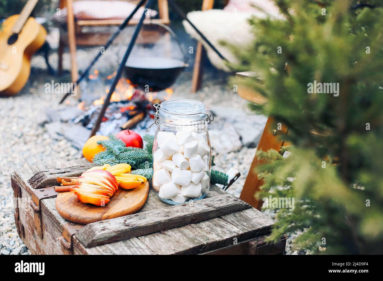 From above traditional mulled wine with slices of orange preparing in pot over burning logs in winter in countryside Stock Photo
