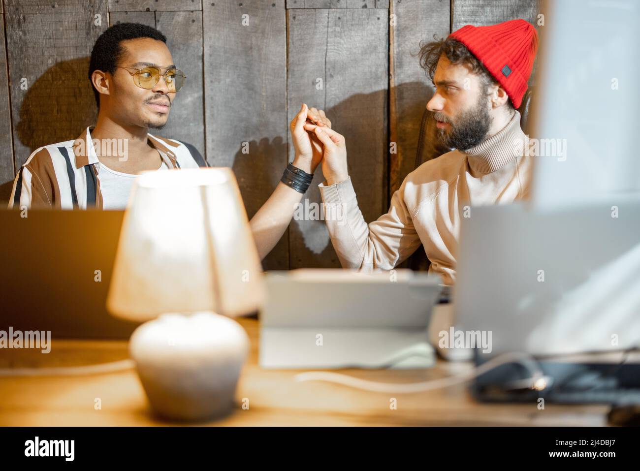 Gay couple working on computers at home office Stock Photo