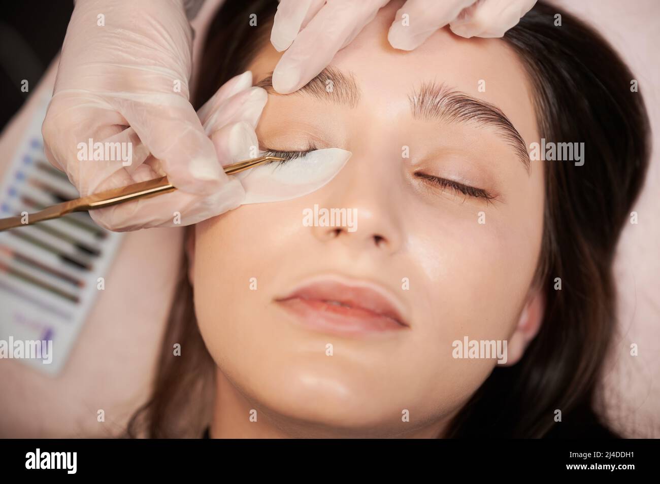 Close up of lash specialist in sterile gloves applying lash extensions