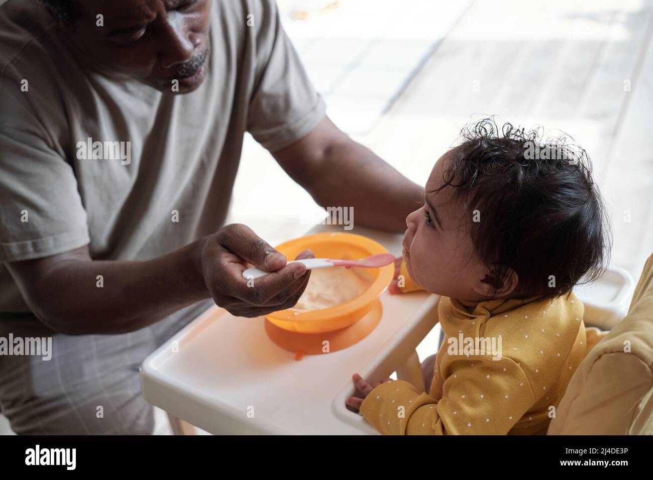 Black mother spoon feeding child hi-res stock photography and images - Alamy
