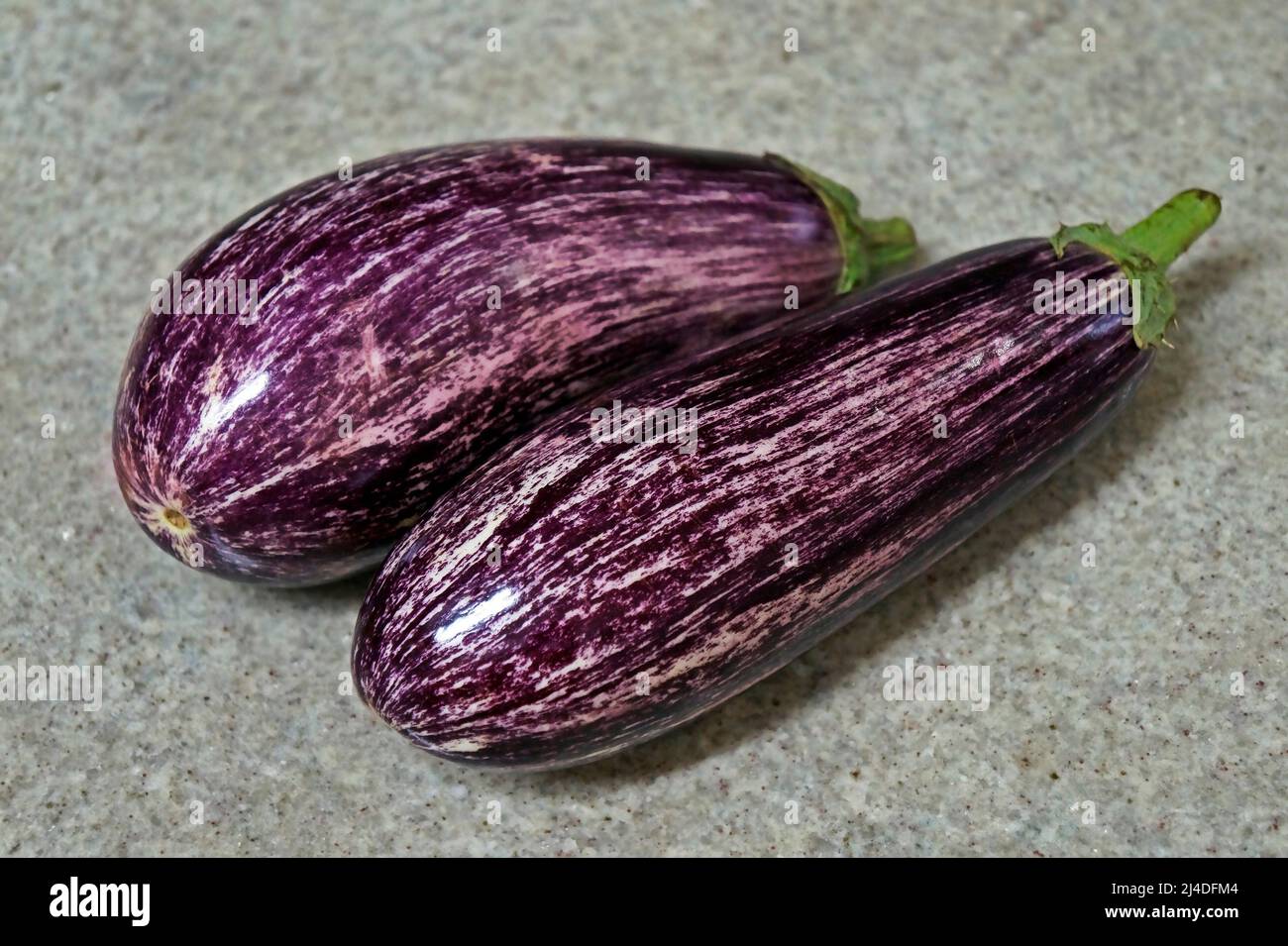 Striped eggplants on granite background Stock Photo