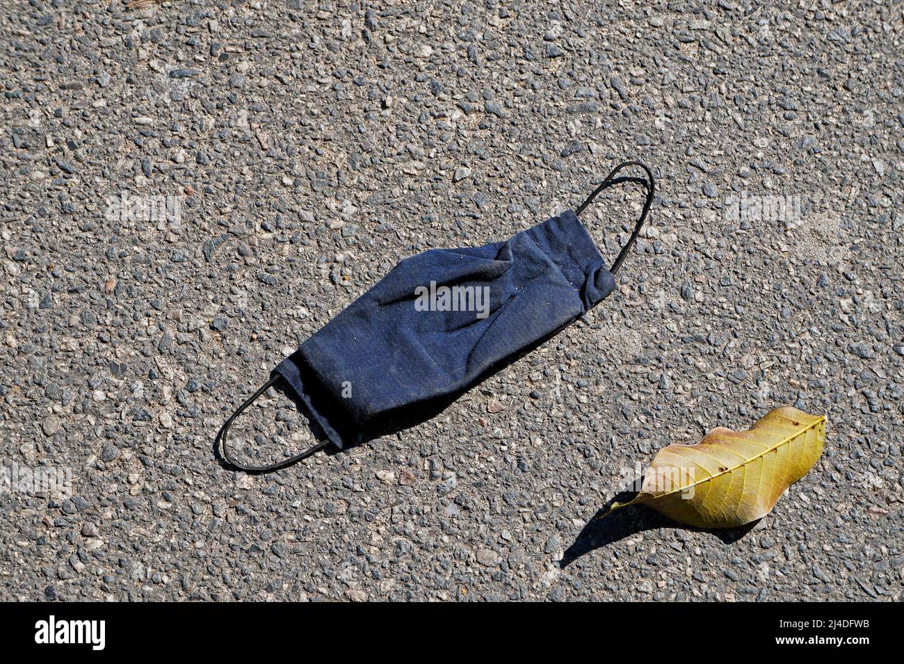 Face mask on floor in street. Improperly discarding used face mask ...