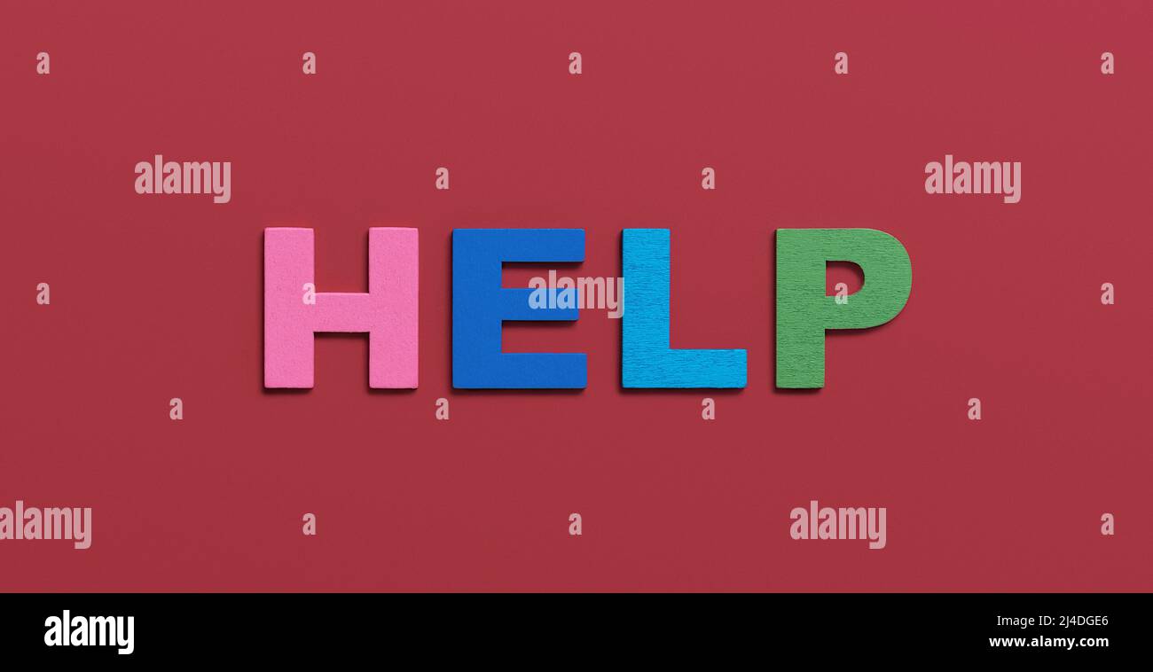 Help, word written in wooden colorful alphabet letters on red ...