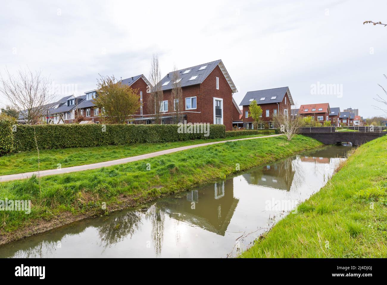 Modern newly build family houses along canal in Kortenoord in Wageningen, Gelderland in The Netherlands Stock Photo
