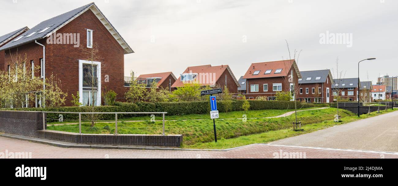 Modern newly build family houses along canal in Kortenoord in Wageningen, Gelderland in The Netherlands Stock Photo