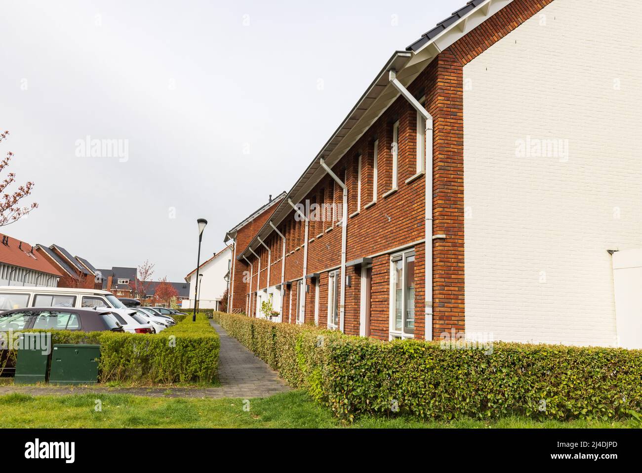 Row of modern newly build family houses along canal in Kortenoord in Wageningen, Gelderland in The Netherlands Stock Photo