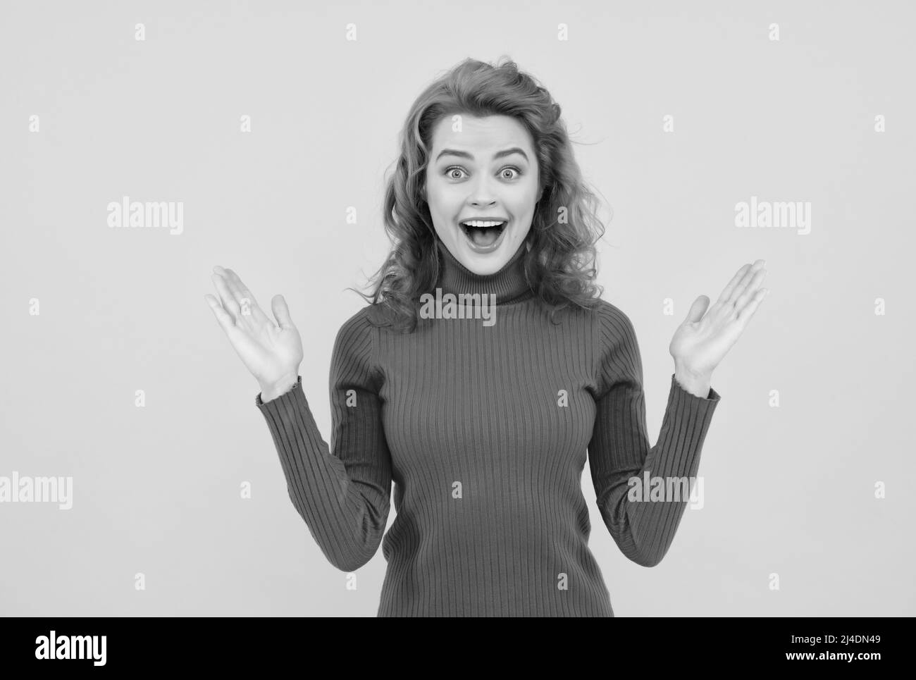 Happy exited surprised women. Image of excited screaming young woman standing isolated over yellow background Stock Photo