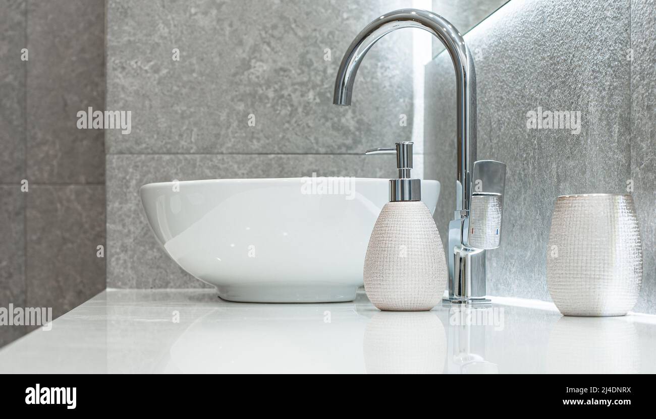 Modern bowl-shaped washbasin with chrome water mixer and soap dispenser in bathroom Stock Photo