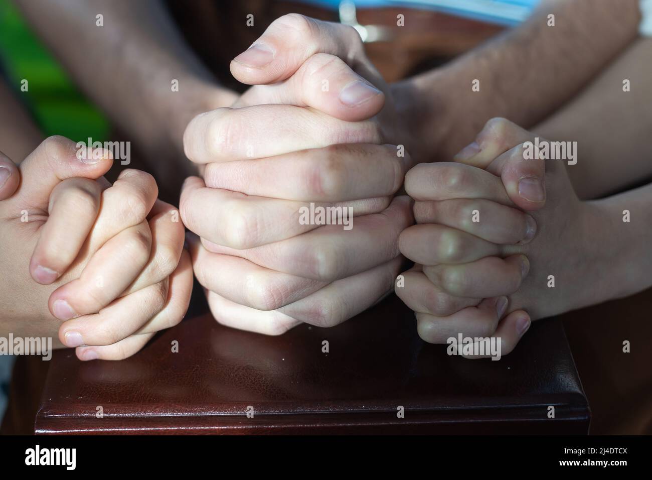 Two Christian people are praying for young man friends on wood table at church prayer room to encourage and support him in his problem and spiritual Stock Photo