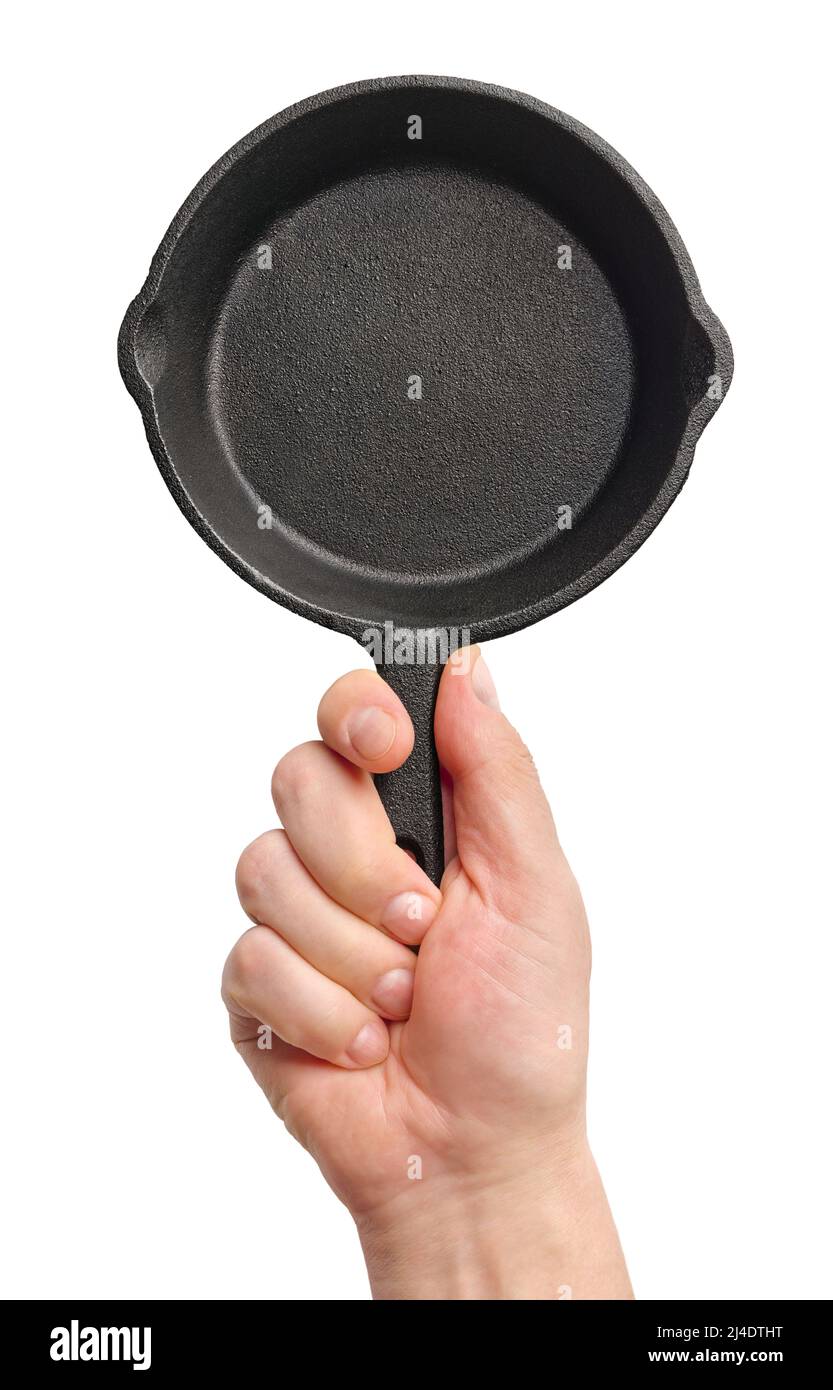 Hand holding black cast-iron frying pan, isolated on white background Stock Photo