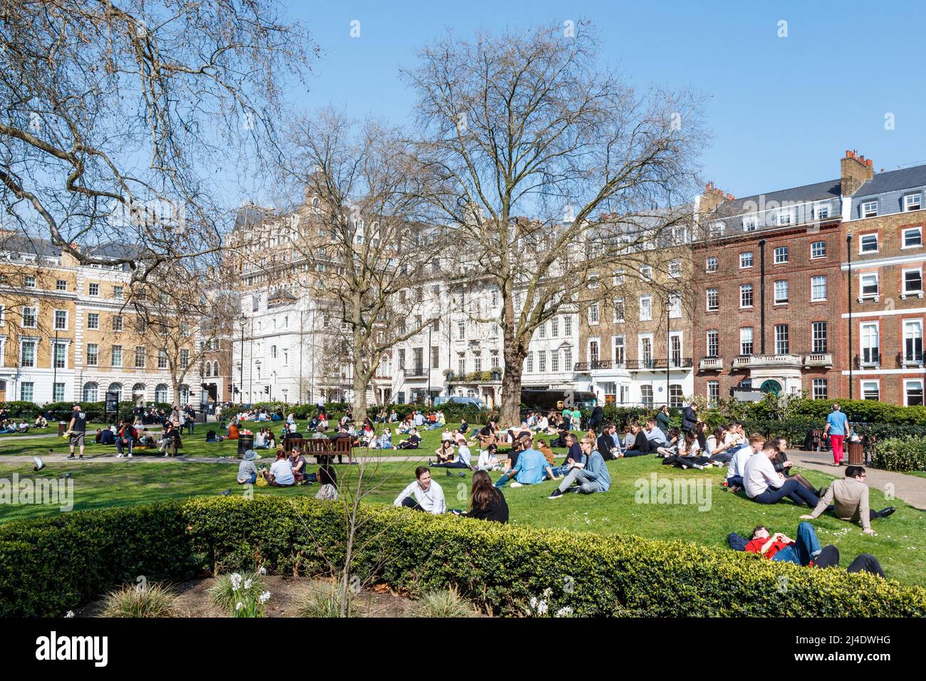 Shop and office workers taking an alfresco break for lunch as warmer weather arrives in the UK, Cavendish Square, London, UK Stock Photo