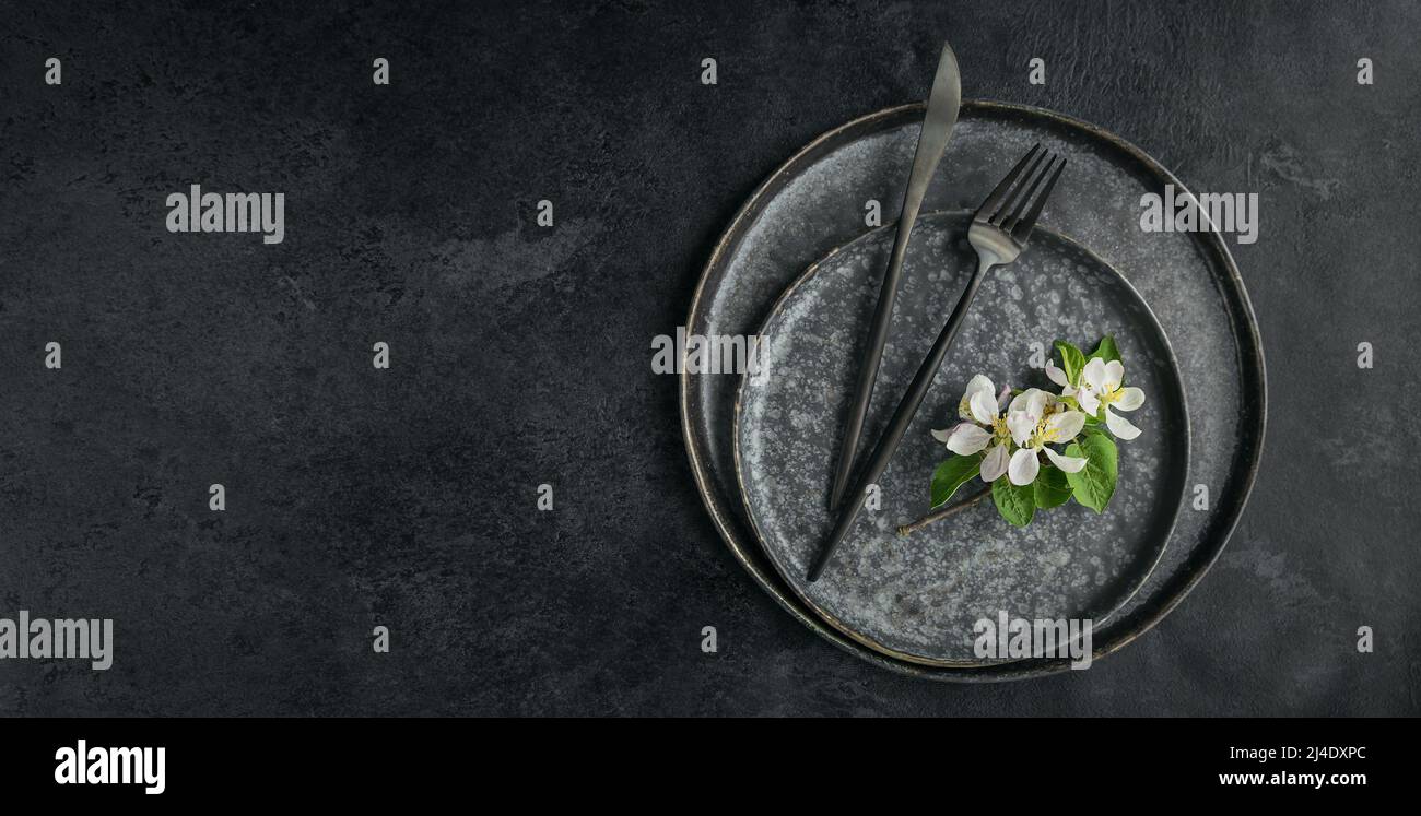 Place table setting with blossoming apple tree branches and flowers Stock Photo