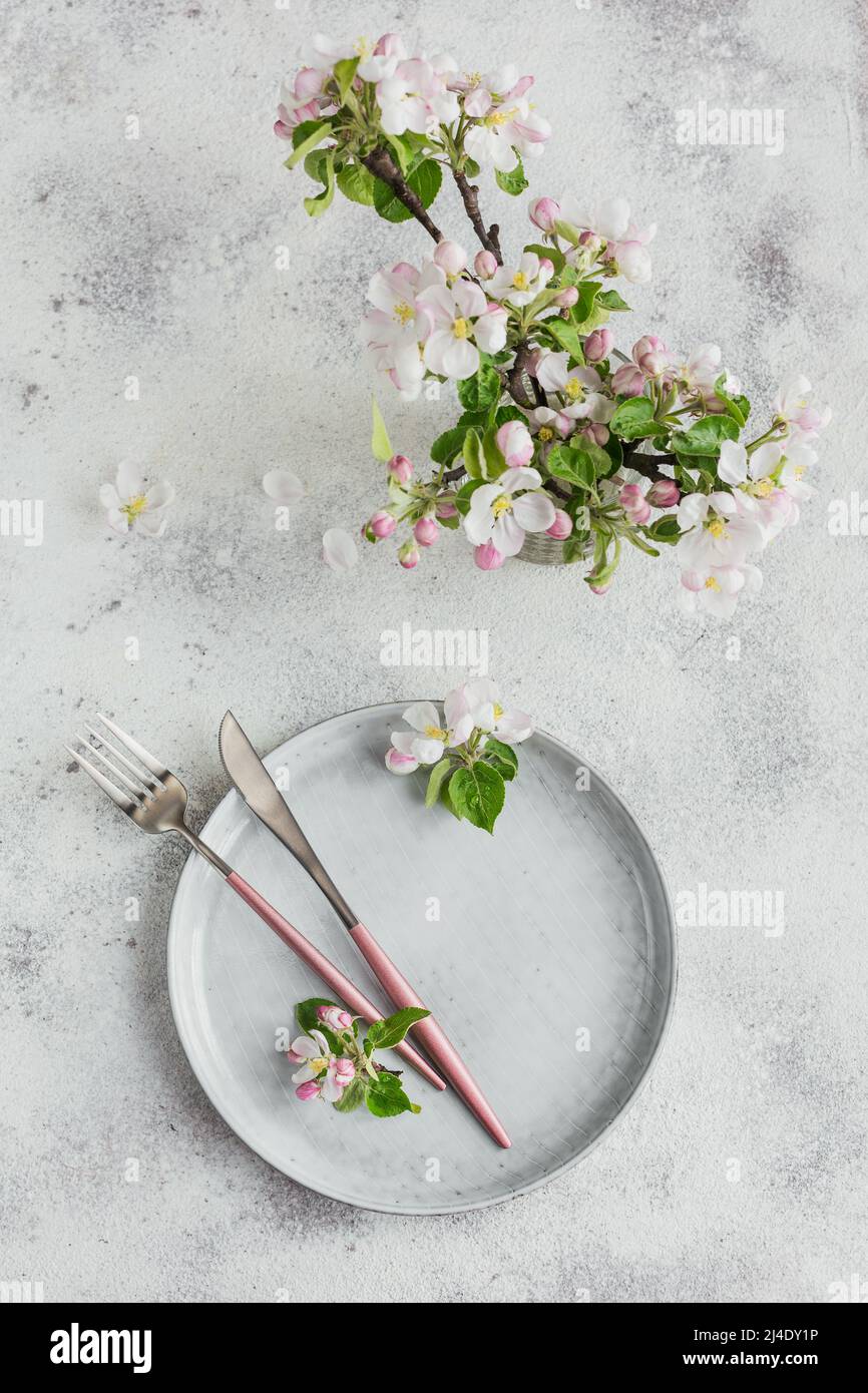 Place table setting with blossoming apple tree branches and flowers Stock Photo