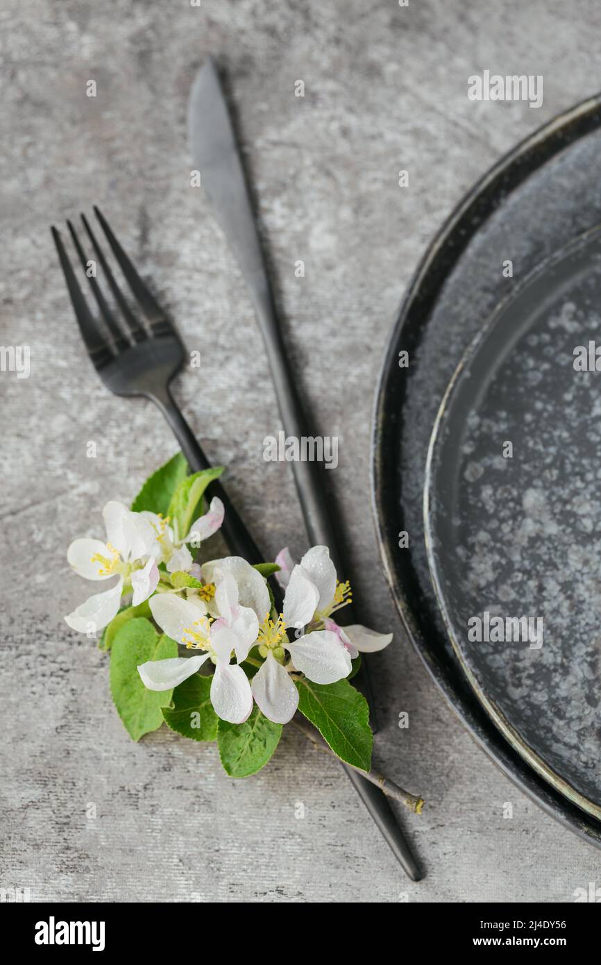 Place table setting with blossoming apple tree branches and flowers Stock Photo