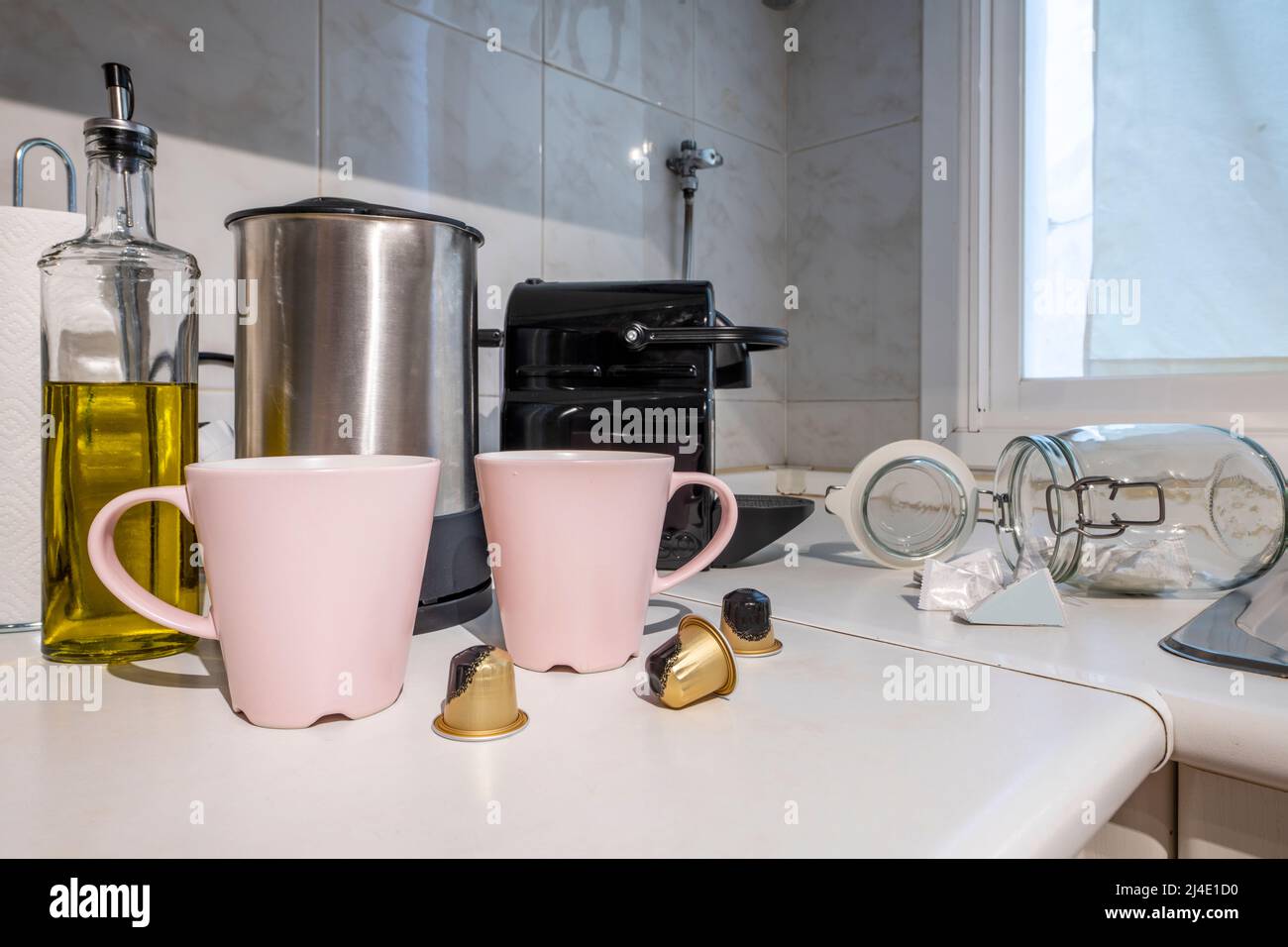 https://c8.alamy.com/comp/2J4E1D0/corner-of-a-kitchen-with-a-pod-coffee-machine-next-to-pale-pink-mugs-next-to-a-stainless-steel-kettle-and-oil-can-2J4E1D0.jpg
