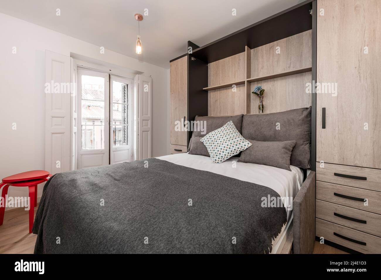 Extended pullout bed with cushions, blankets and white bedding in