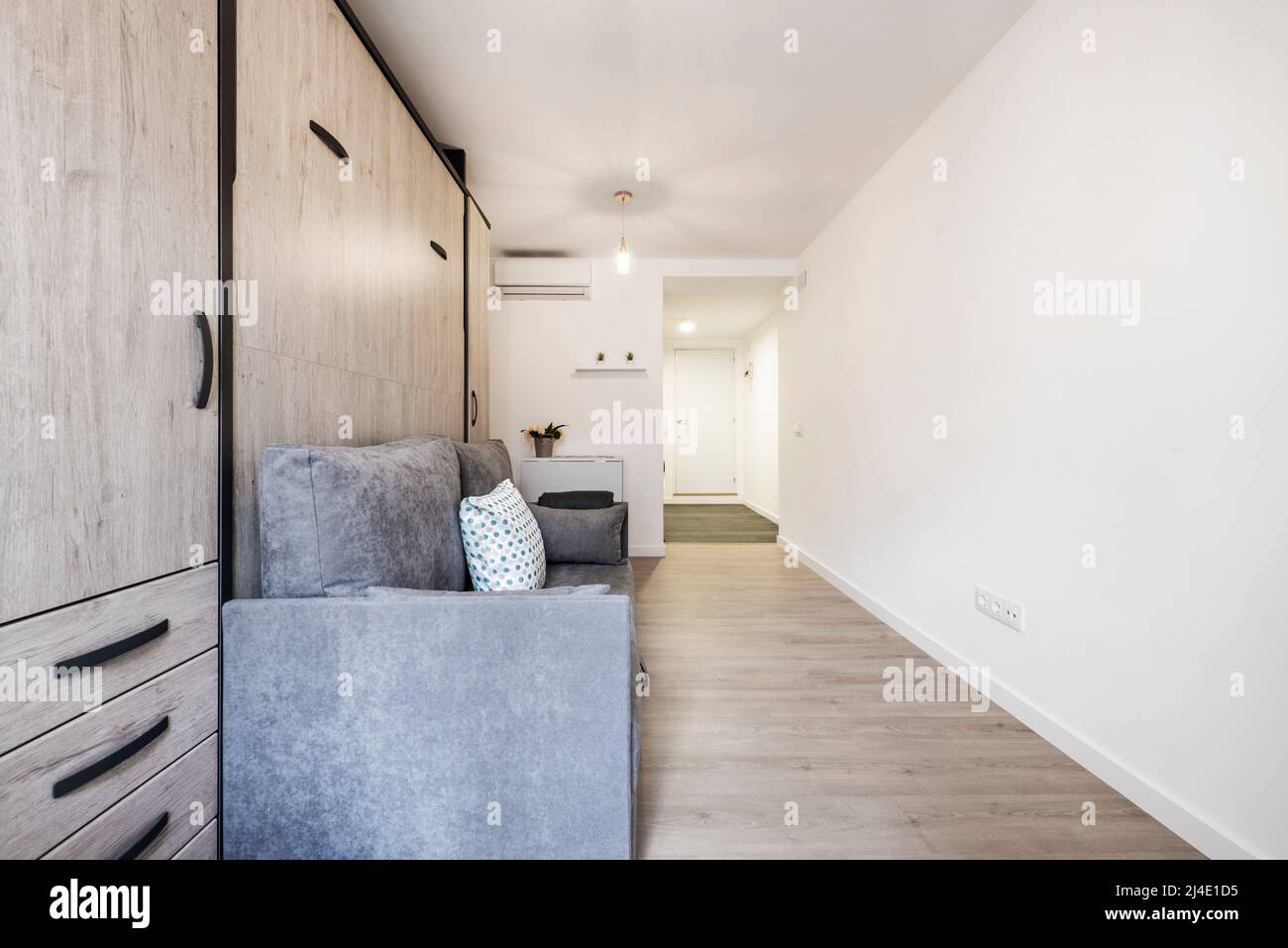 Rollaway bed inside sofa with cushions in shortterm rental studio Stock Photo Alamy