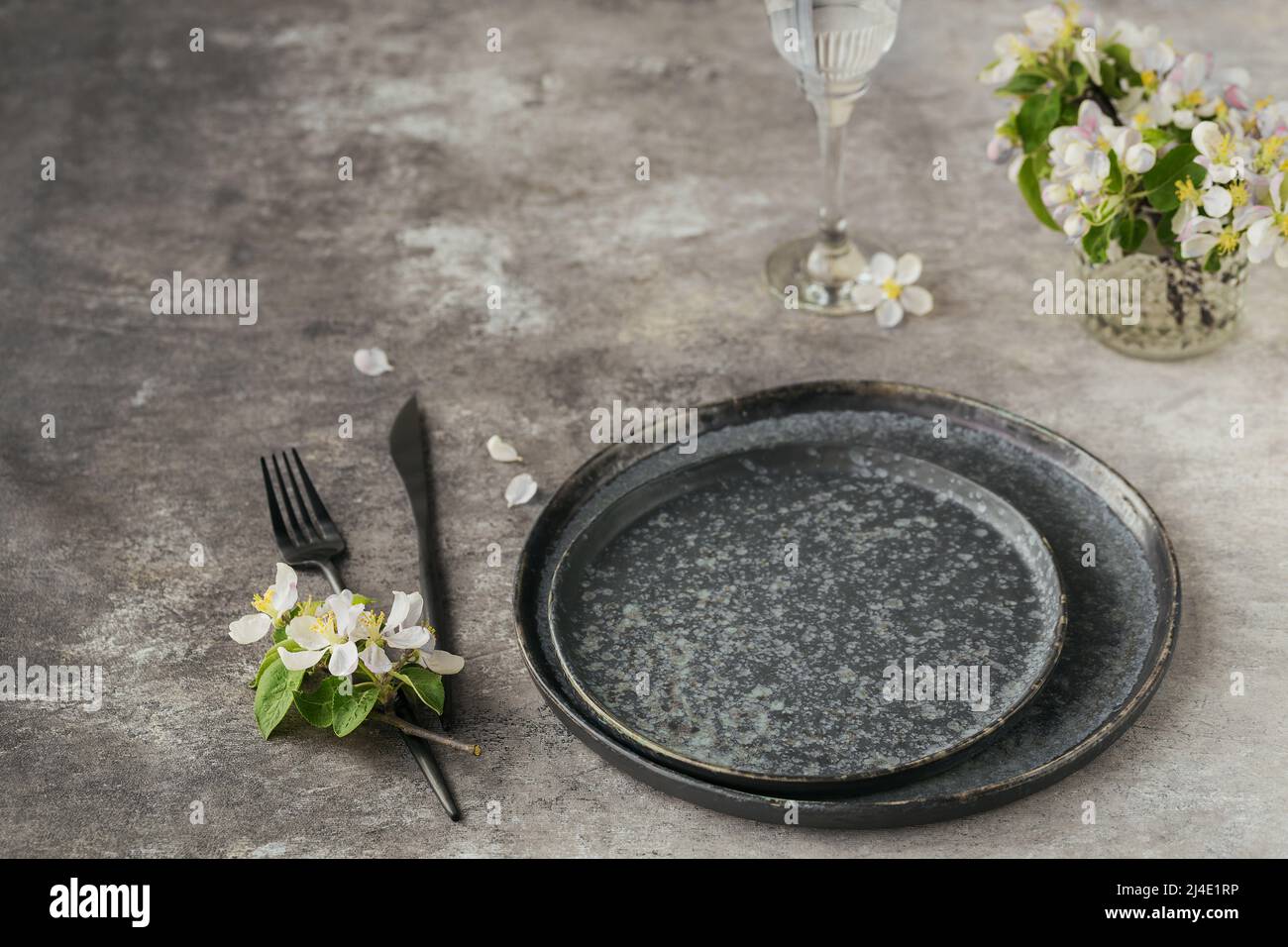 Place table setting with blossoming apple tree branches and flowers Stock Photo