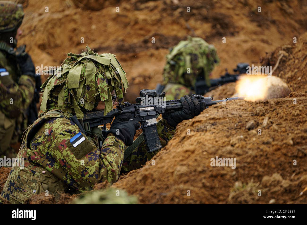 Estonian soldiers return fire as they defend a dug-in position from attacking British armour and infantry in the Tapa central military training area in Estonia on NATO exercise Bold Dragon alongside Danish and French forces. Picture date: Thursday April 14, 2022. Stock Photo