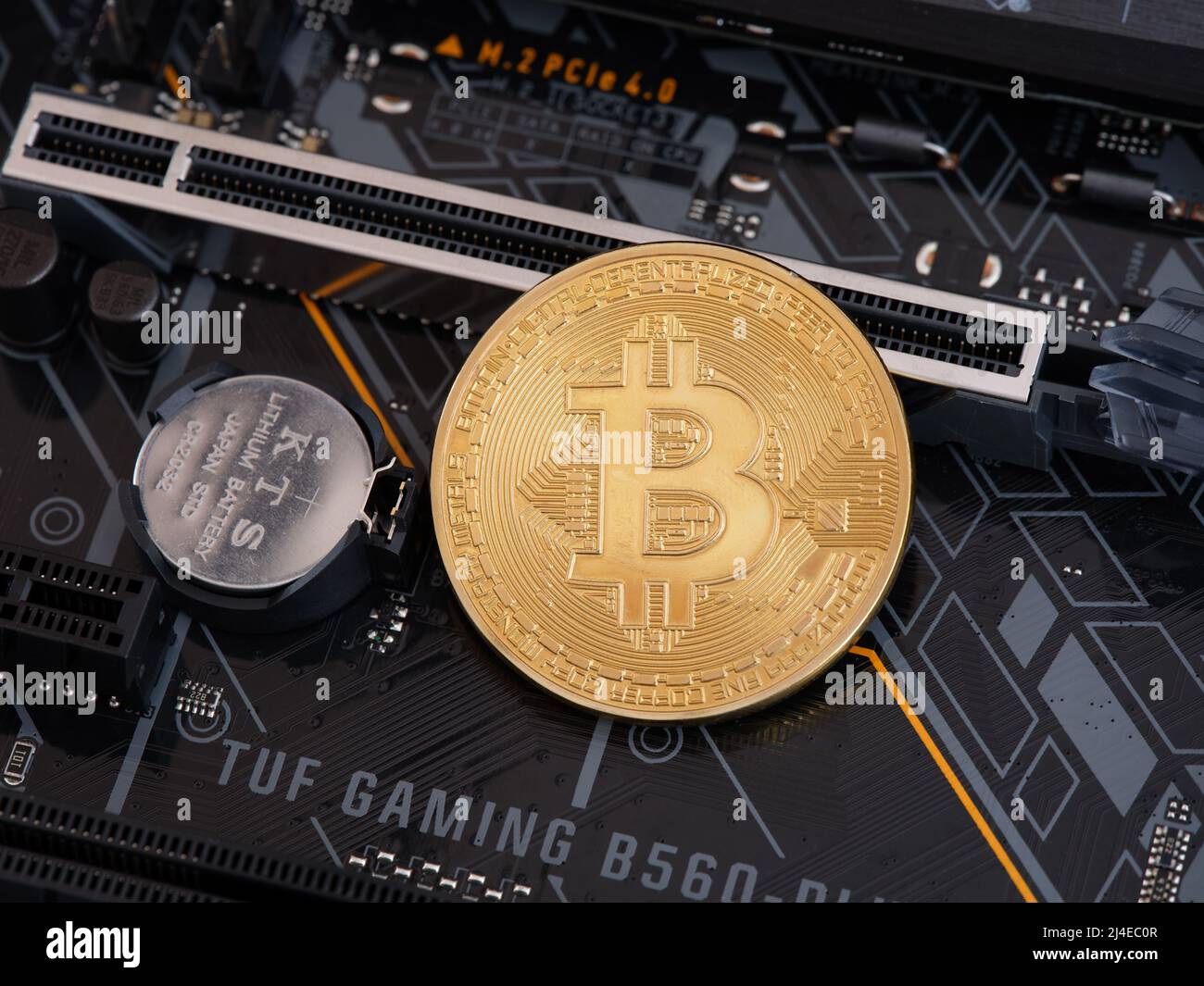 Tambov, Russian Federation - April 10, 2022 A Bitcoin Cryptocurrency lying on a PCI Express slot that is on a TUF Gaming Motherboard. Low key. Close u Stock Photo