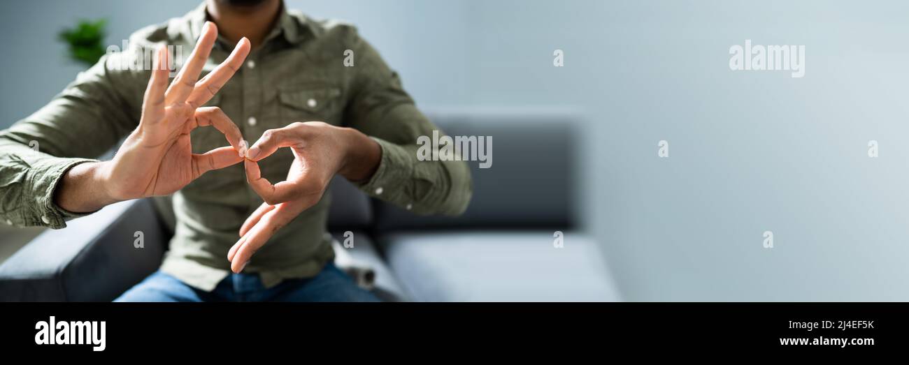 Man Using Sign Language To Communicate At Home Stock Photo