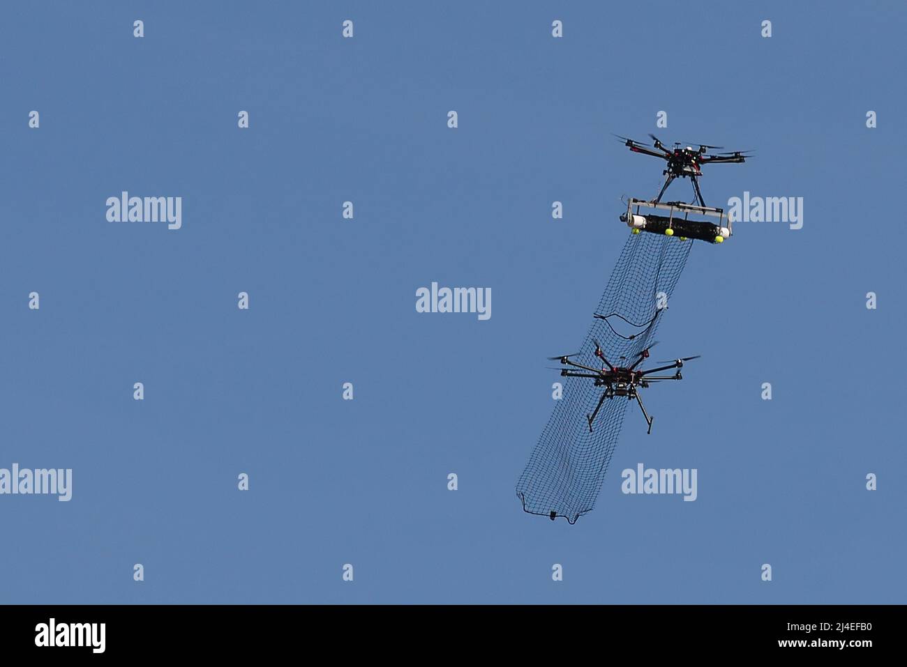 An attack drone with attached net, part of the counter-unmanned aerial system developed by the team from Wright-Patterson Air Force Base, Ohio, intercepts a DJI S1000 drone with its net during the 2016 Air Force Research Laboratory Commanders Challenge at the Nevada National Security Site, Las Vegas, NV., Dec. 13, 2016. Teams were given six months to develop a complete counter-unmanned aerial system to aid in base defense. In addition to the attack drone, Wright-Patterson's system uses a camera and laser range finder to detect UAS devices. (U.S. Air Force photo by Wesley Farnsworth) Stock Photo