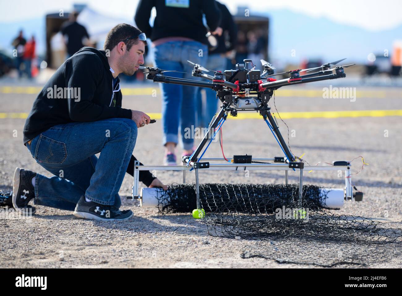 U.S. Air Force 2nd Lt David Feibus, with team Flying Gatorz from Wright-Patterson Air Force Base, Ohio, checks the attached net on his team's attack drone between scenarios during the 2016 Air Force Research Laboratory Commanders Challenge at the Nevada National Security Site, Las Vegas, NV., Dec. 13, 2016. Teams were given six months to develop a complete counter unmanned aerial system to aid in base defense. Wright-Patterson's system uses a camera and laser range finder to detect UAS devices and an attack drone with attached net for intercepting and retrieving them. (U.S. Air Force photo by Stock Photo