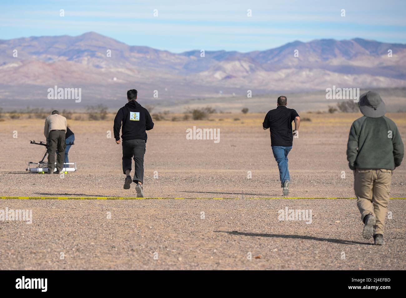 Members of team Flying Gatorz from Wright-Patterson Air Force Base, Ohio, rush to reset their attack drone between scenarios during the 2016 Air Force Research Laboratory Commanders Challenge at the Nevada National Security Site, Las Vegas, NV., Dec. 13, 2016. Teams were given six months to develop a complete counter-unmanned aerial system to aid in base defense. Wright-Patterson's system uses a camera and laser range finder to detect UAS devices and an attack drone with attached net for interception and retrieval. (U.S. Air Force photo by Wesley Farnsworth) Stock Photo
