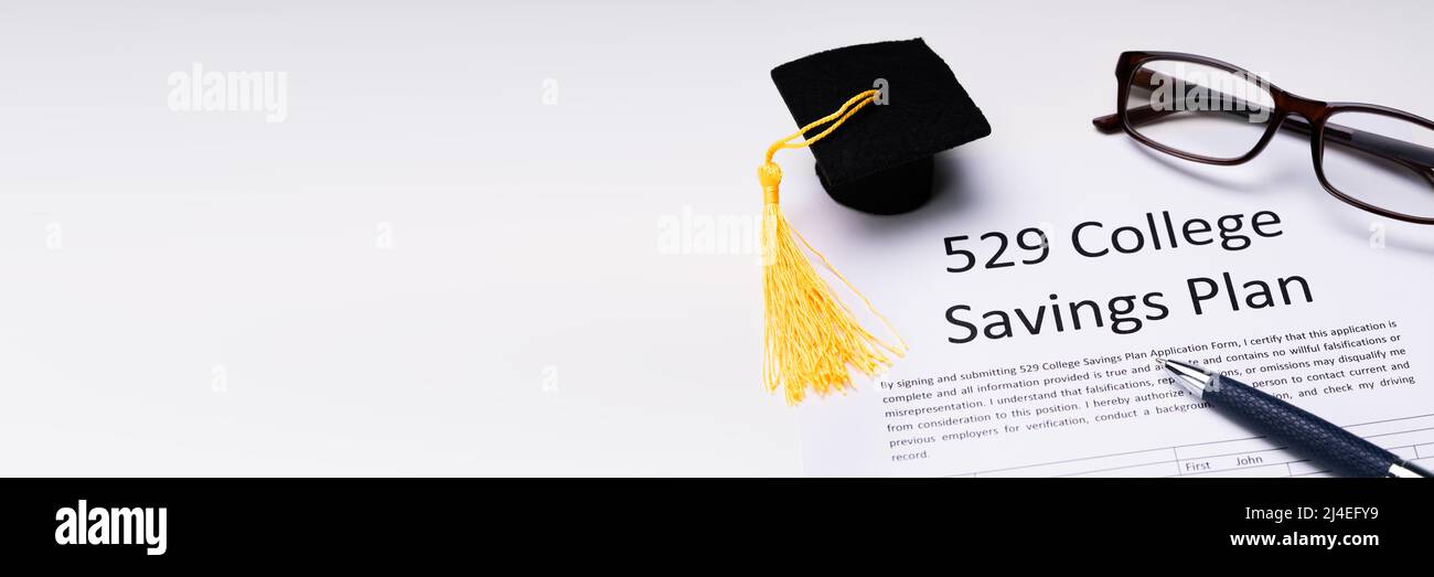 529 College Savings Plan Form With Small Graduation Hat, Spectacles And Pen Over White Background Stock Photo