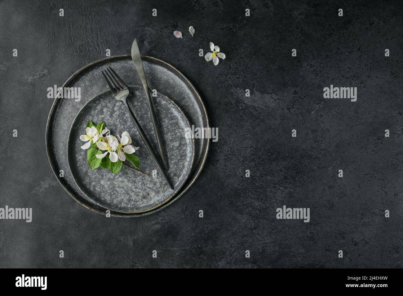 Place table setting with blossoming apple tree branches and flowers Stock Photo