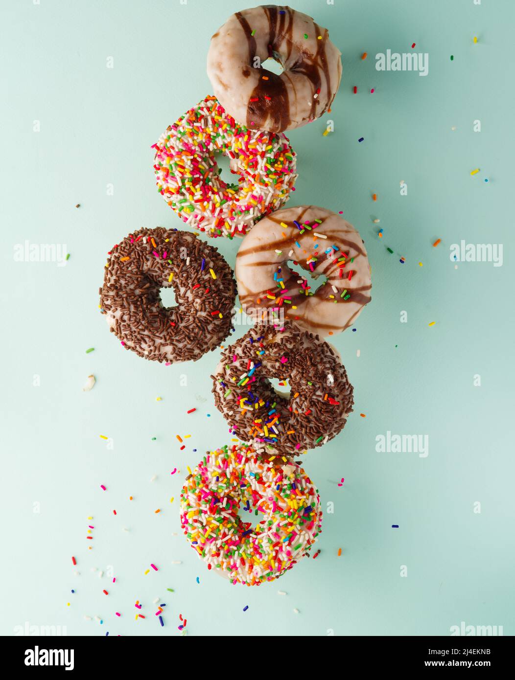 Multi-colored donuts covered with chocolate and sugar icing on a light ...