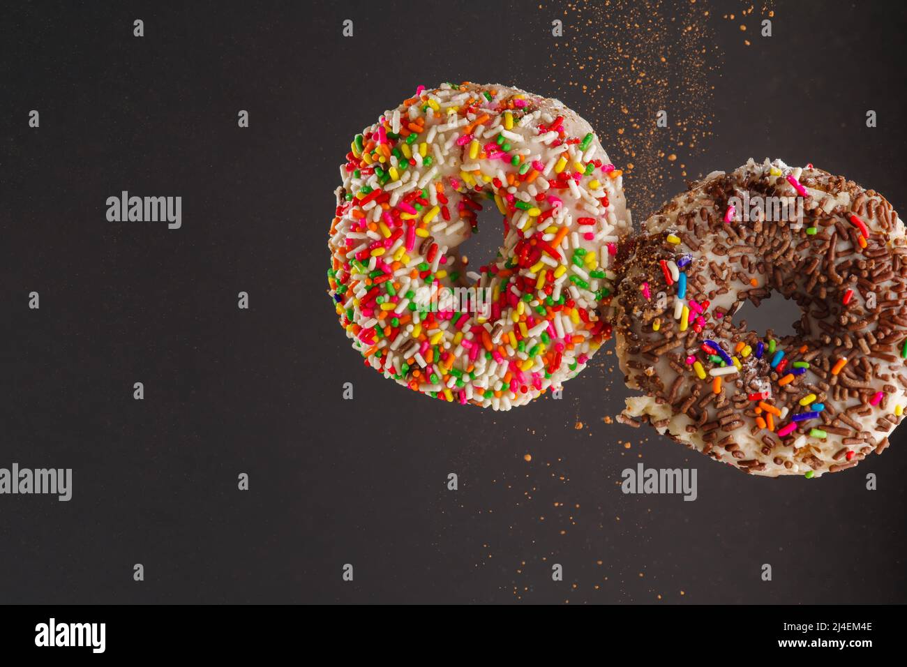 Two sweet donuts with sugar icing and multicolored confectionery