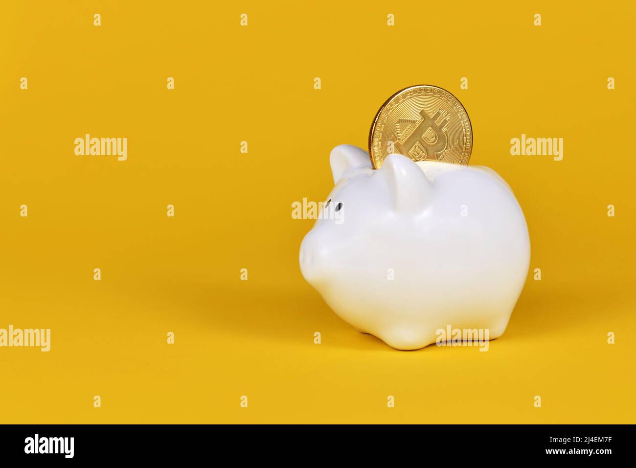 Crypto currency bitcoin in white piggy bank on yellow background Stock Photo
