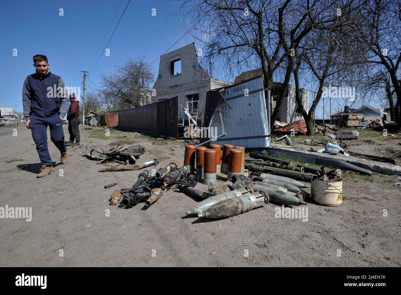 A man walks past artillery ammunition abandoned by the Russian army in the village of Andriivka, Kyiv region about 50 km from Kyiv. The Ukrainian Parliament at a meeting on Thursday, April 14, recognized the Russian war as genocide against Ukraine. The deputies voted for the Resolution on the Statement of the Ukrainian Parliament of Ukraine on the commission of genocide by the Russian Federation in Ukraine. Russia invaded Ukraine on 24 February 2022, triggering the largest military attack in Europe since World War II. Stock Photo