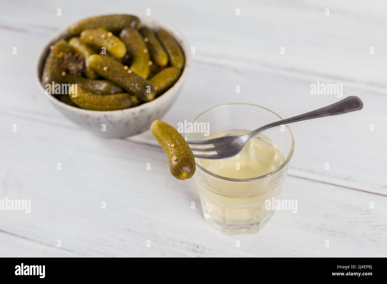 Pickled juice, pickle and marinated cucumber in bowl Stock Photo